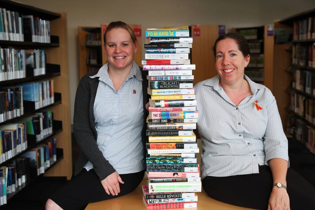STOCKPILING: Council employees Jeannie Hazell and Wendy Harper test the 30-book borrowing limit at Wagga library. Picture: Emma Hillier
