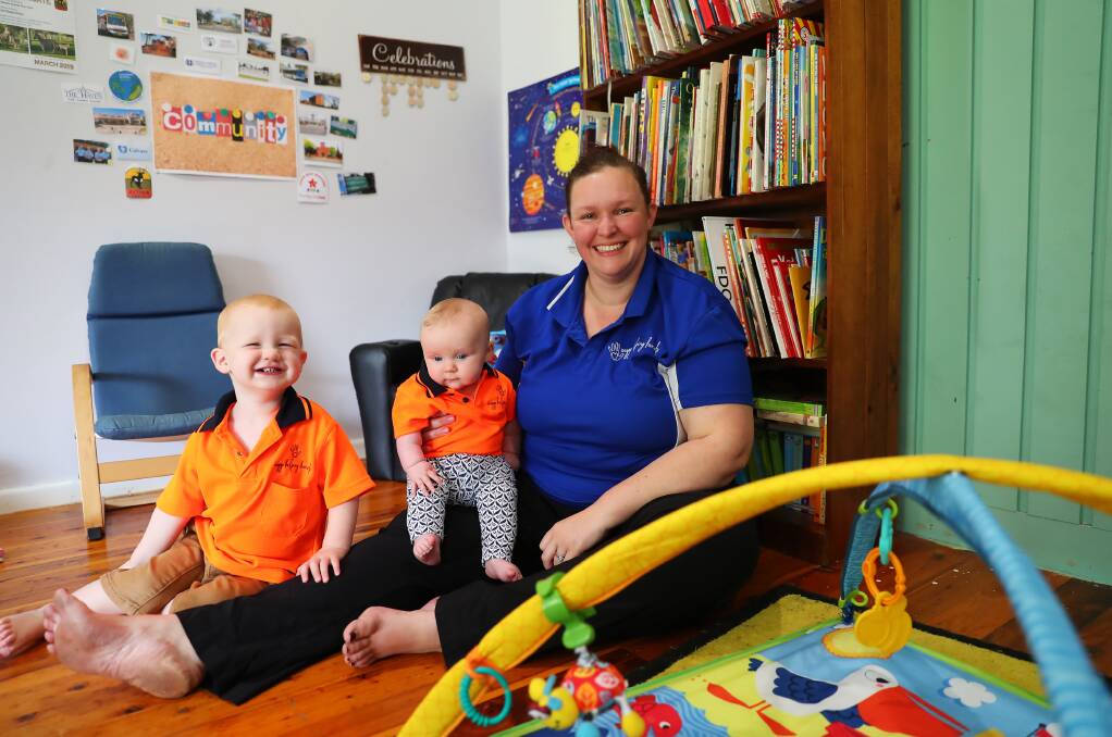 BEST IN THE BUSINESS: Childcare educator Rachel Smith with her six-month-old daughter Adelyn and one-year-old daycare attendee Ziggy Cheney at the award-winning Mount Austin business premises. Picture: Emma Hillier