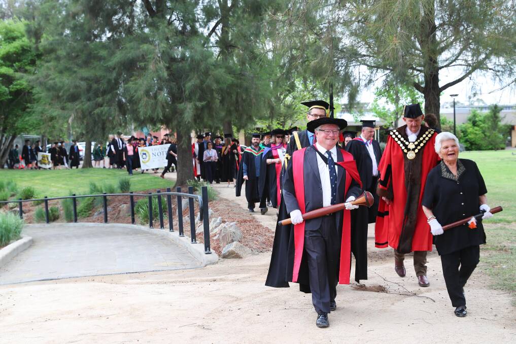 Former deputy vice chancellor Professor Ken Dillon, and Aunty Isabel Reid lead the 2018 procession. Picture: Emma Hillier