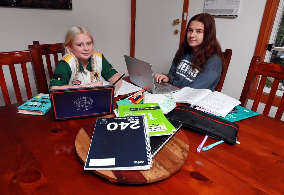 AT HOME FOR NOW: Adelle and Hayley Cummins, aged 12 and 14, will continue to study at home while they discuss what a return to school will look like for them in week 3. Picture: Les Smith