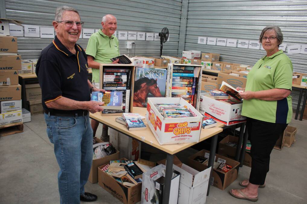 SORTERS SOUGHT: Wagga Rotarians Neil Hilpern, Gerry Page and Vicky Donoghue in a warehouse full books. Picture: Emma Horn