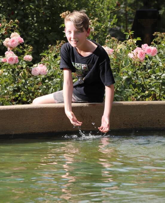 SUMMER SIZZLE: Ben Gray 12, finds a way to cool off in the Victory Memorial Gardens. Picture: Les Smith