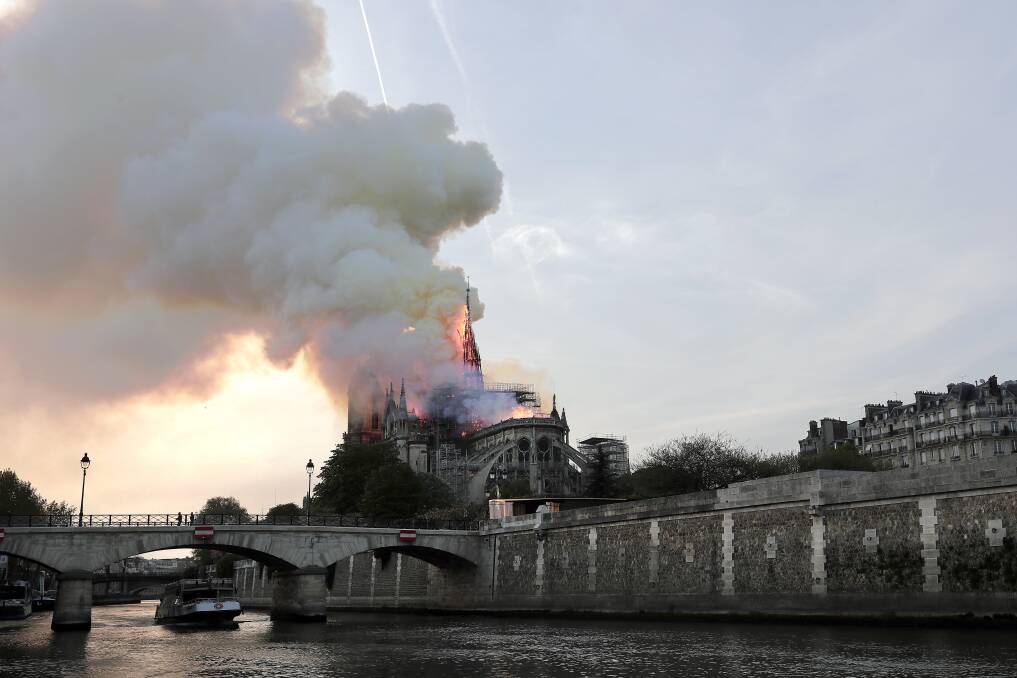 DEVASTATED: The spire collapses while flames engulf the Notre Dame Cathedral in Paris. 'Notre Dame' translates to 'Our Lady'. Picture: Ian Langsdon