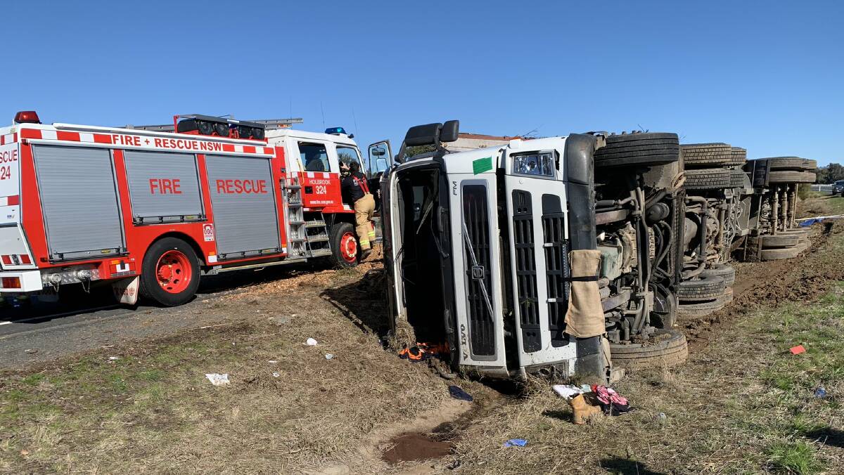 A truck laden with bark chips rolled near Holbrook on Monday, sending the driver to hospital and causing delays along the Hume Highway. Picture: Fire and Rescue NSW