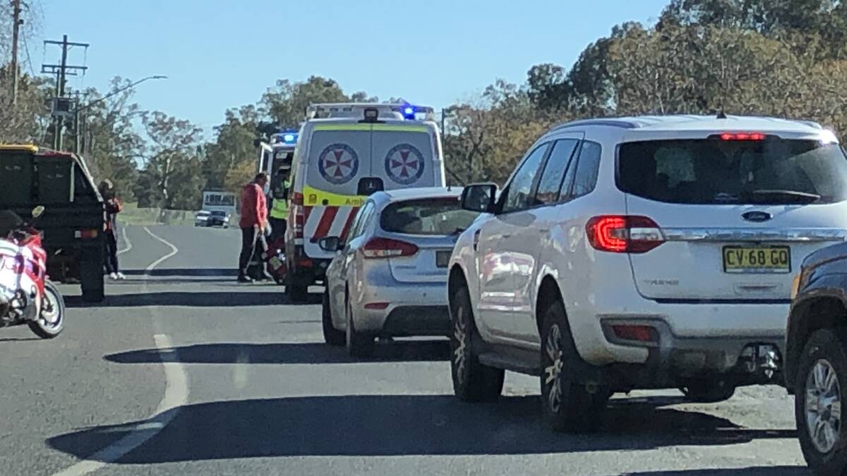 Traffic comes to a standstill as paramedics treat a man thrown from his motorcycle in a two-vehicle crash on Travers Street. Picture: Courtney Rees