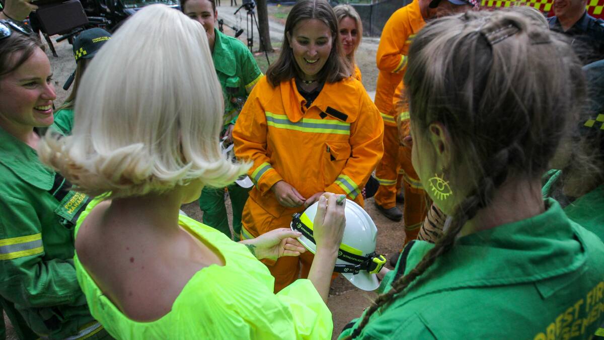 Katy Perry signs a firefighter's helmet at her concert in Bright on Wednesday. Picture: Blair Thomson