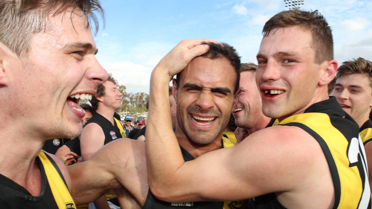 ON A HIGH: Sam Ryan, Jesse Manton and Tom Keogh - sans a tooth he lost during the game - celebrate the Tigers' grand final win over Griffith.