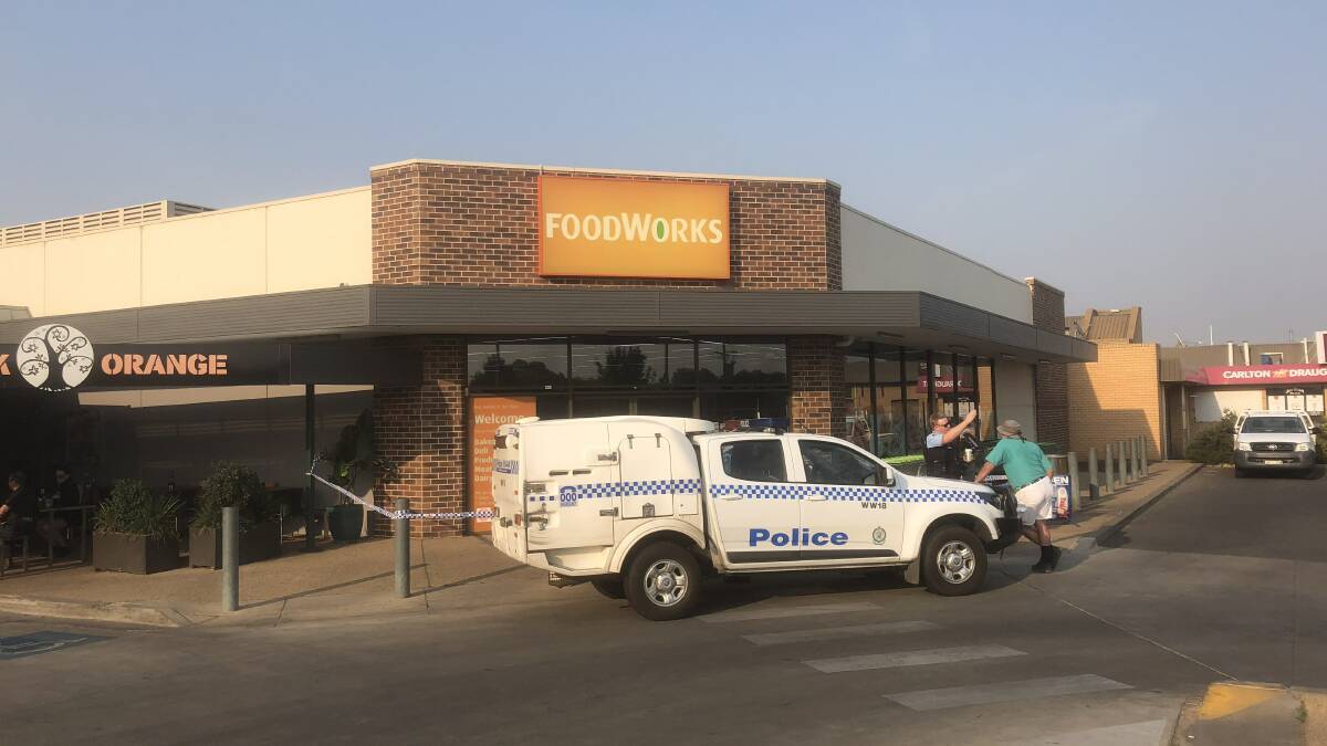STAY CLEAR: Police talk to a bystander outside the Lake Albert Foodworks after it was robbed on Monday morning. Picture: Rex Martinich