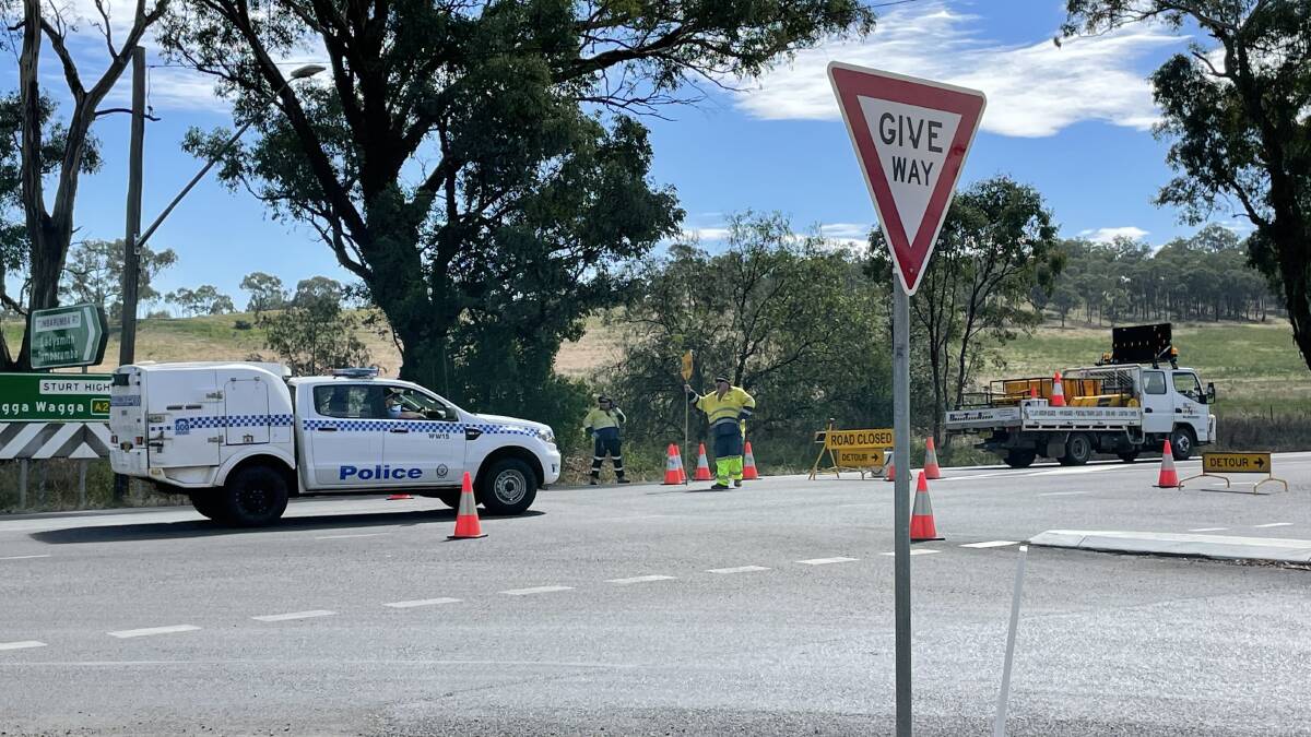 BLOCKED: Police and traffic controllers at the Tumbarumba Road intersection. Picture: Rex Martinich