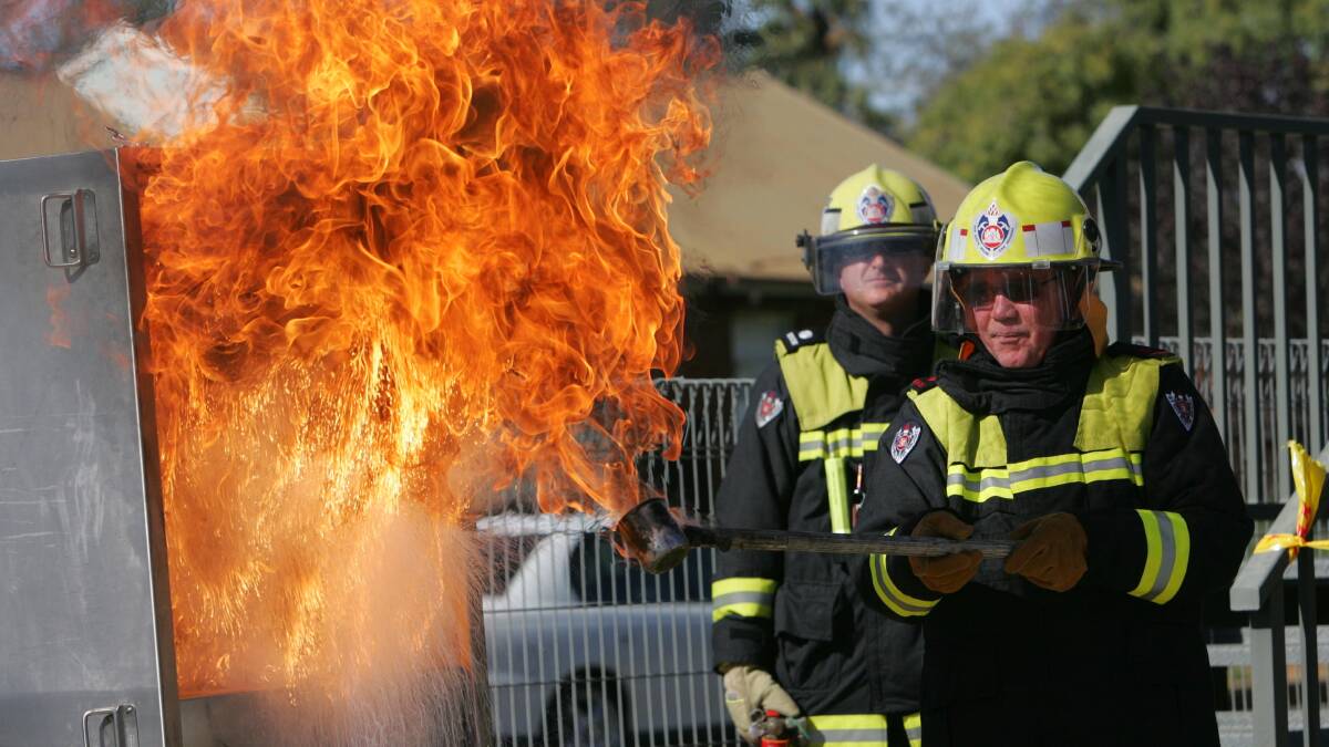 Firefighter David Gill pours water into an oil fire during a safety demonstration at the Turvey Park FRNSW station in 2010. File image