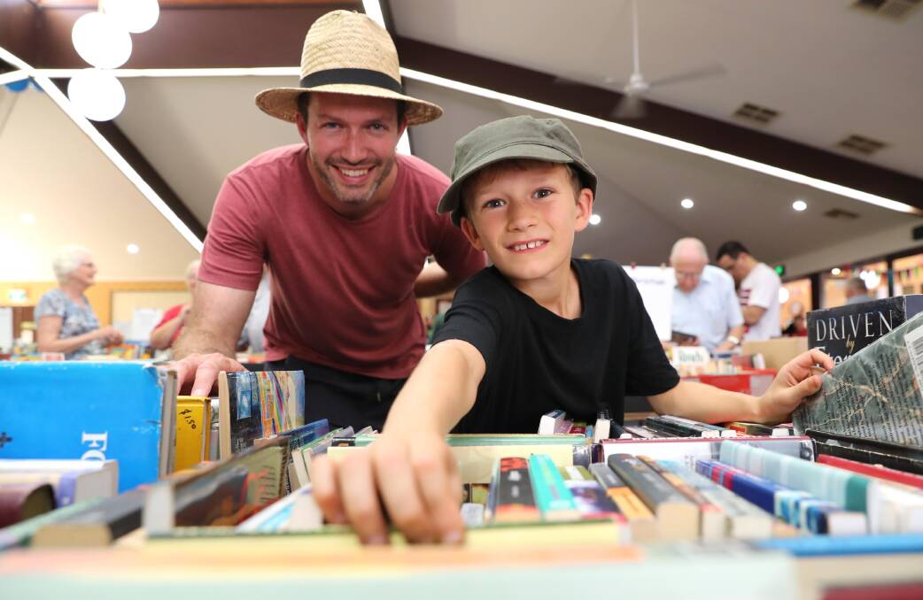 TREASURE TROVE: Geoffrey Xeros and his son Sebastian, 8, trawl through an endless collection of books at the monster garage sale. Picture: Les Smith
