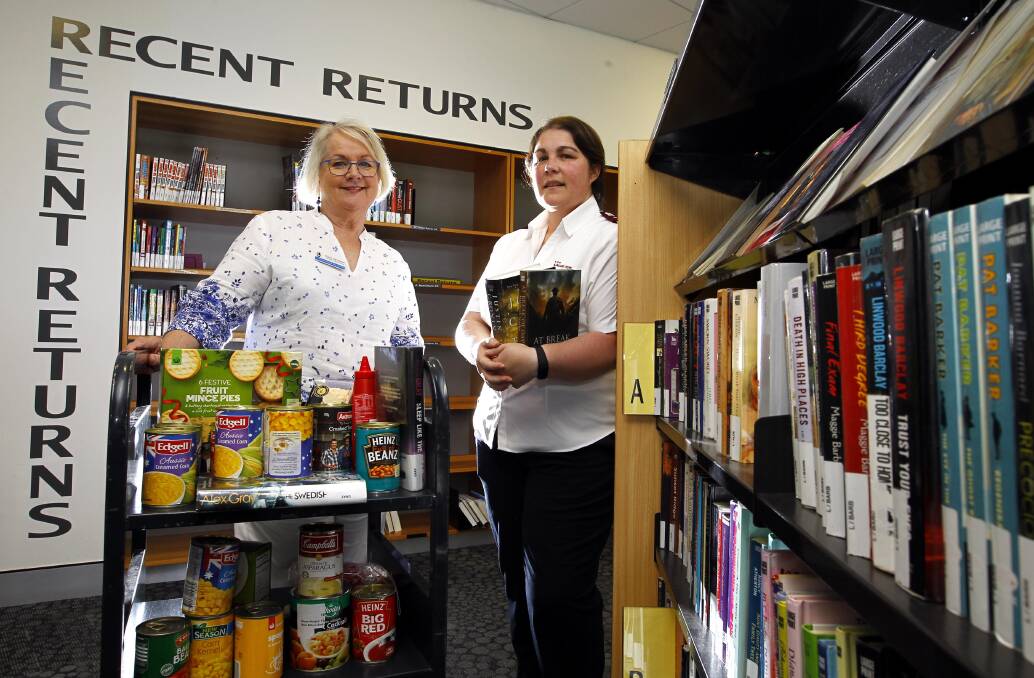 CHRISTMAS SPIRIT: Library manager Claire Campbell and Bindy Lupis from the Salvos with last year's donated food. Picture: Les Smith