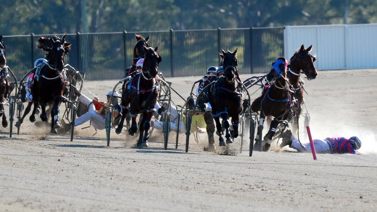 CRASH LANDING: Nathan Hoy, Todd Day and Shane Hallcroft all avoided serious injury in this fall at Riverina Paceway on Friday. Picture: Les Smith