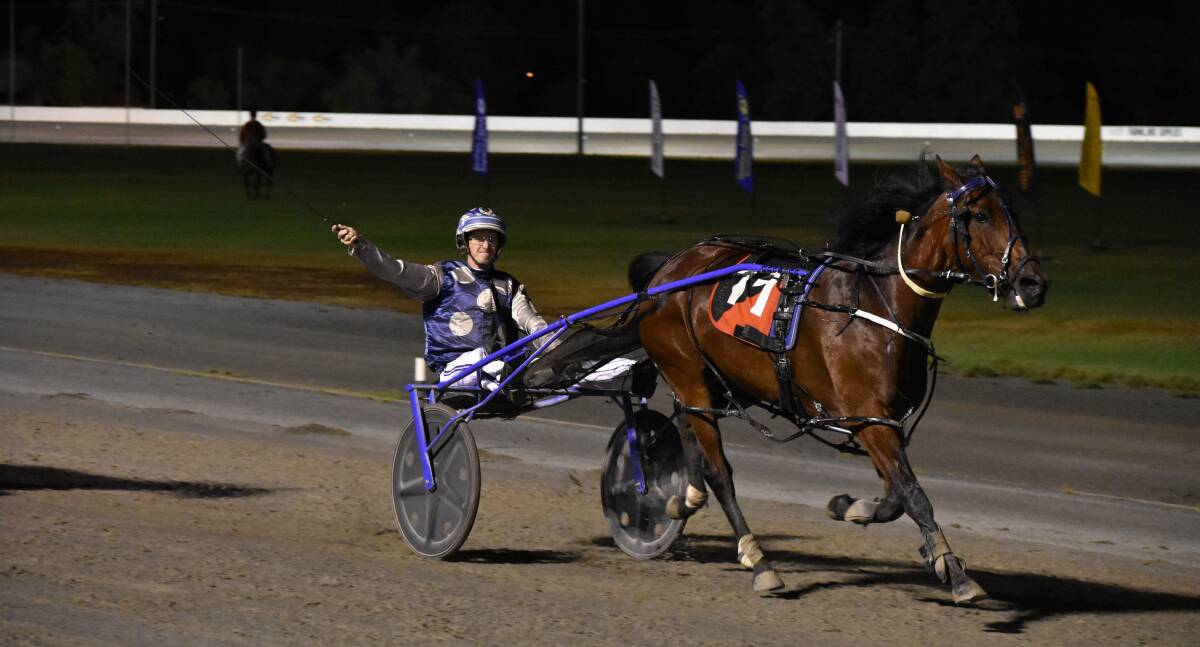 BIG SALUTE: Reinsman Blake Jones celebrates after driving Deekays Dollar to special win in the Laurie Kennedy Memorial at Leeton on Tuesday night. Picture: Courtney Rees