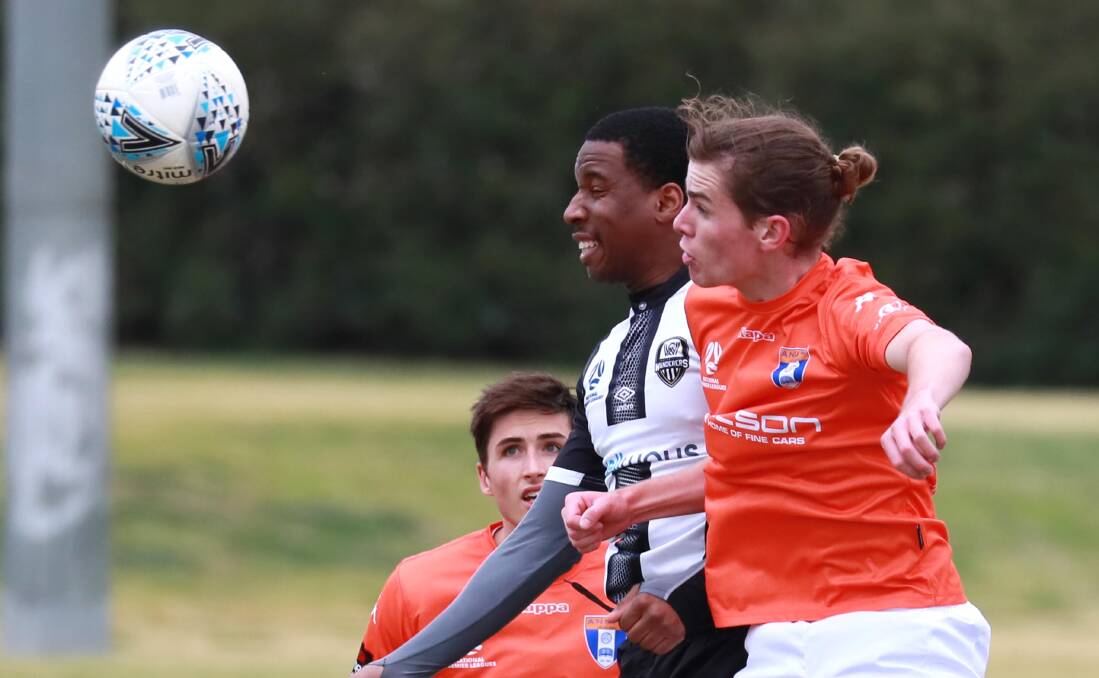 TIGHT TUSSLE: Alvaro Kelechi and Hugh O'Brien battle for the ball as ANU scored a 3-2 win over Wagga City Wanderers on Saturday. Picture: Les Smith