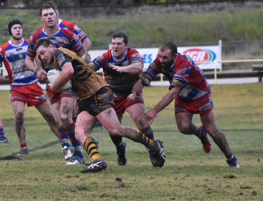 SLIPPING AWAY: Troy Barby looks to escape the clutches of James Woolford and Blake Hewitt in Gundagai's win over Young at Alfred Oval on Sunday. Picture: Courtney Rees