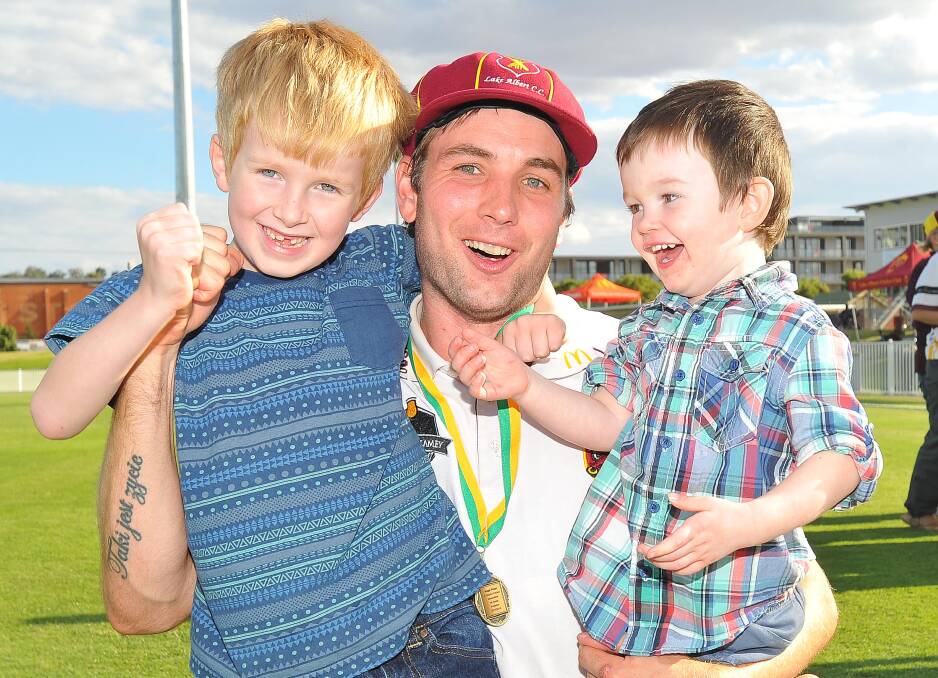 Nicoll celebrating Lake Albert's 2016 grand final win with sons Josh and Oliver.