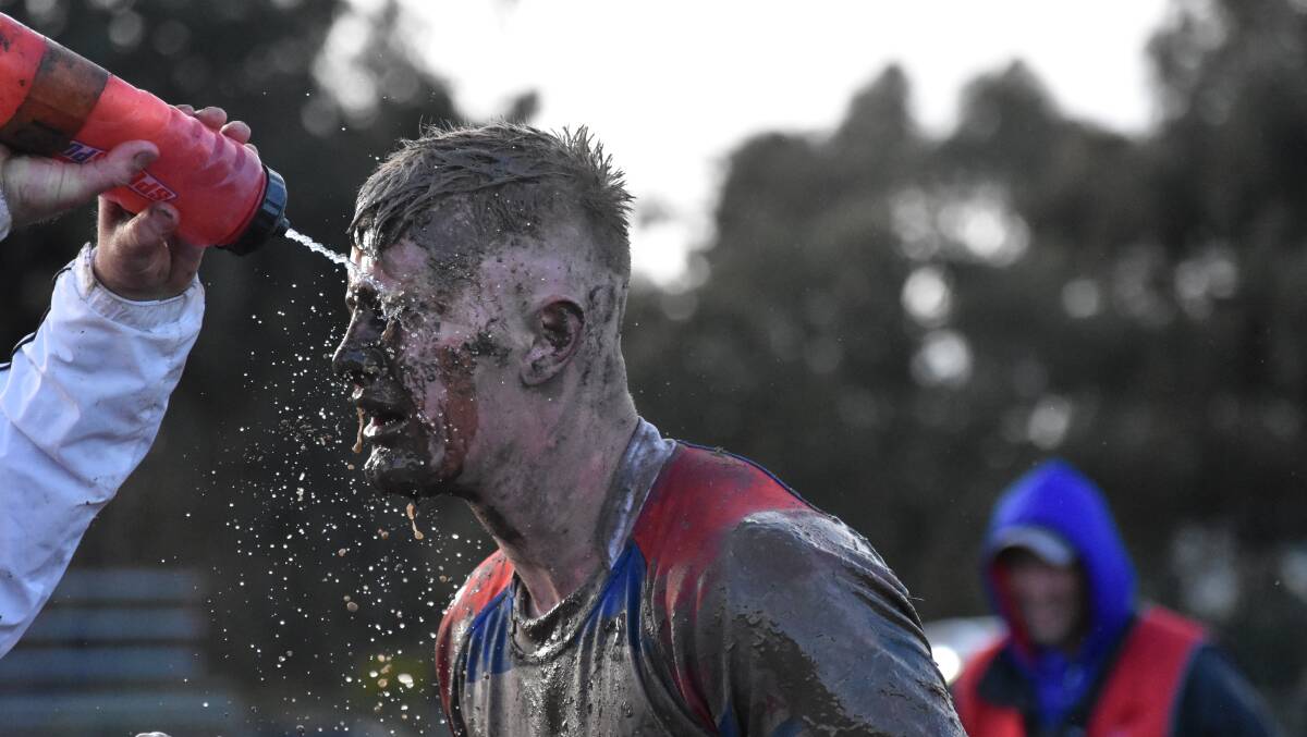 Young centre Tom Jenkins gets some of the mud removed from his face during Young's win over Kangaroos on Sunday.