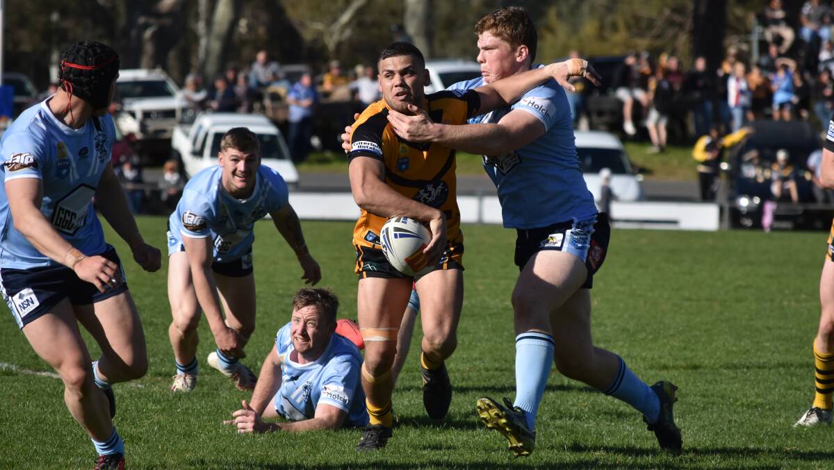 ON THE ATTACK: Mathew Lyons tries to fire out a flick pass under pressure from Michael Fenn in Gundagai's loss to Tumut at Anzac Park on Saturday. Picture: Courtney Rees
