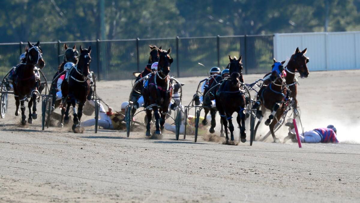 All horses and drivers, including Shane Hallcroft (right) were uninjured in this fall at Riverina Paceway last month.