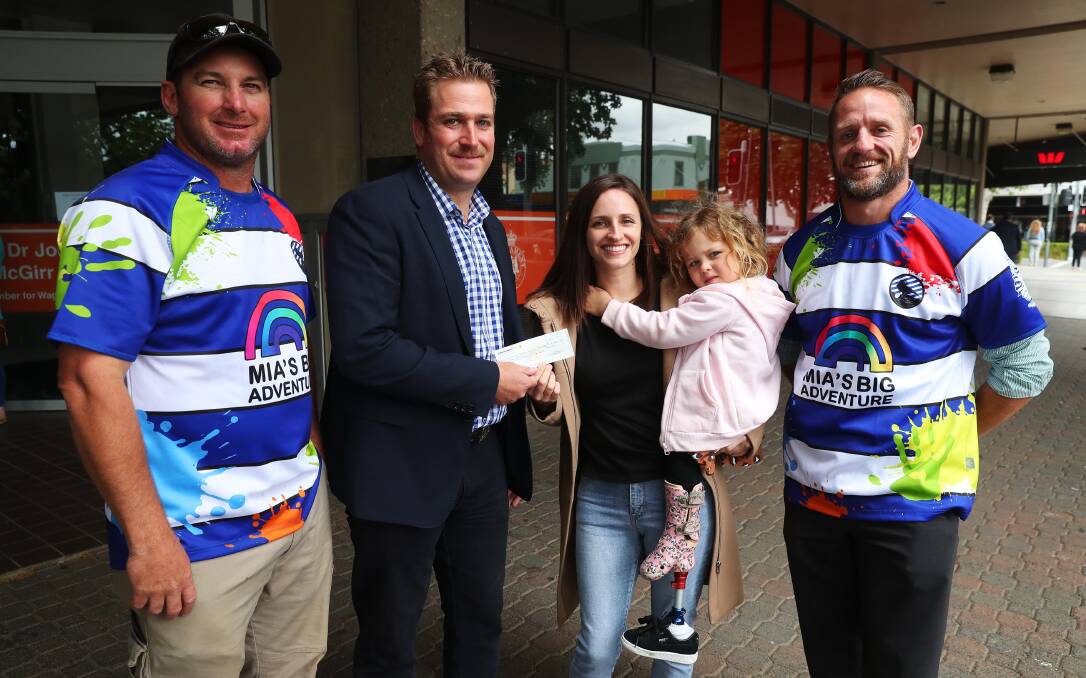 FOR A GOOD CAUSE: Karl Moore, Dan Ribot, and Josh Crockatt (right) present Leila Bright and Mia Stewart, 4, with a cheque from their fundraising efforts.