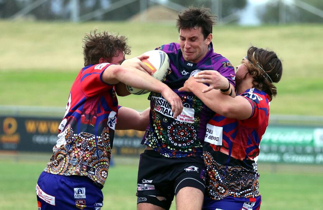 TRIPLE TREAT: Southcity fullback Jake Dooley, pictured trying to break out of tackle from Hayden and Lachlan Jolliffe, scored a hat-trick in the win over old club Kangaroos at Equex Centre on Saturday. Picture: Les Smith