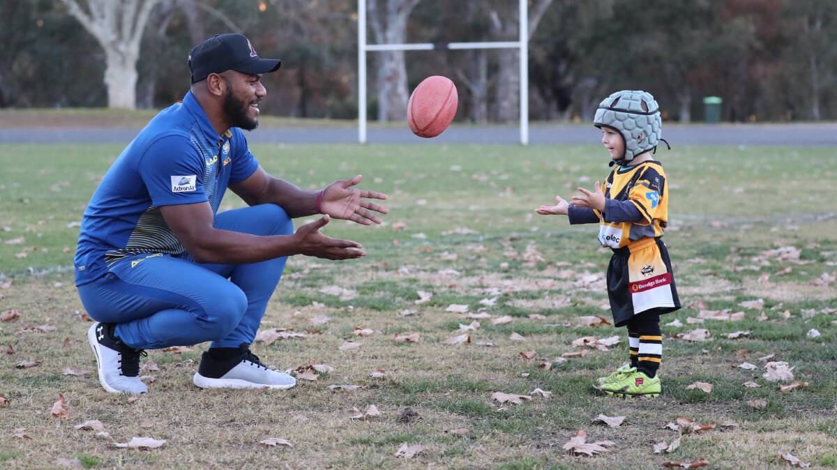 STAR ATTRACTION: Maika Sivo passes the ball with Jayden Smart, 2, as the Parramatta Eels flyer returned to Anzac Park on Friday for a special training session. Picture: Les Smith
