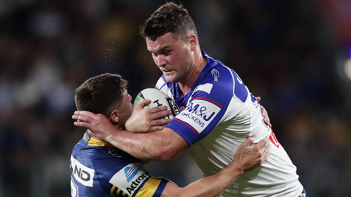 NEW COLOURS: Joe Stimson looks to escape from a Mitchell Moses tackle during his first game for the Bulldogs last month. Picture: Getty Images