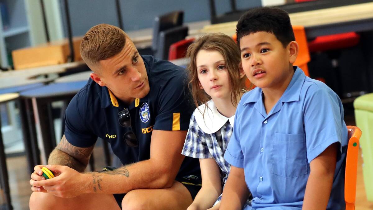 KING OF THE SCHOOL: Parramatta Eels utility Cameron King with Sacred Heart Primary School students Emily Jordan, 10, and Jarm Arcadio, 9, on Friday. Picture: Les Smith