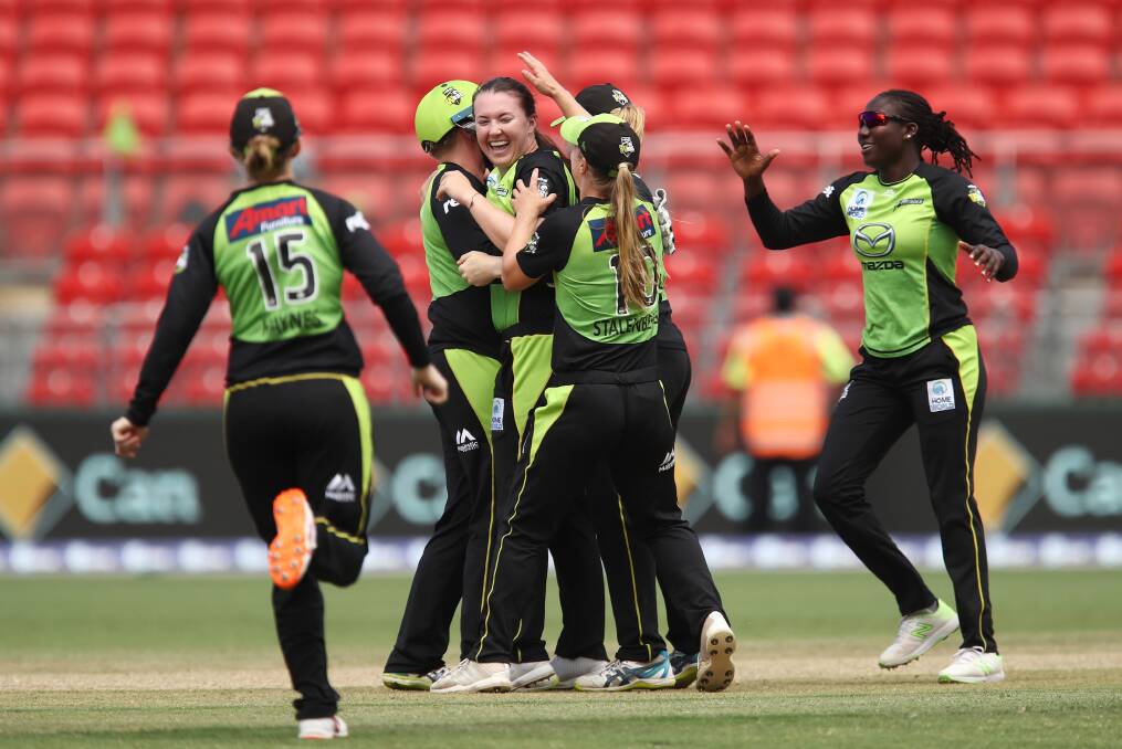 SPECIAL MOMENT: Rachel Trenaman is swamped by teammates after taking her first wicket in the WBBL on Saturday.