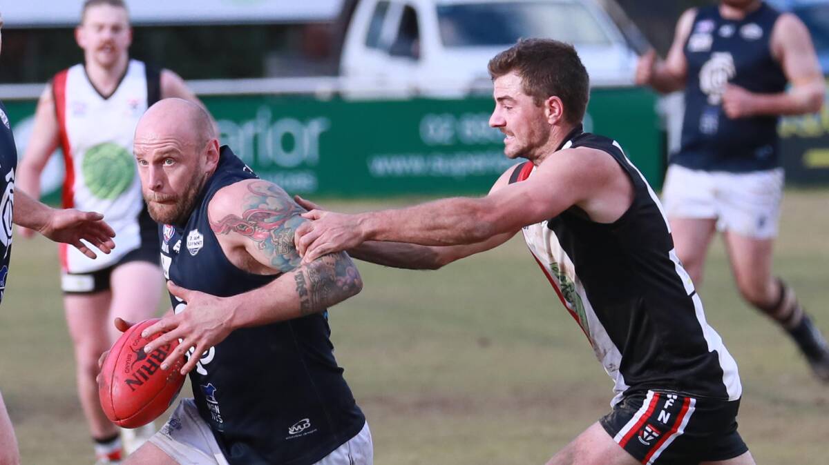HEAT IS ON: Guy Orton tries to escape the clutches of Cayden Winter in Coleambally's heavy loss to North Wagga at McPherson Oval on Saturday. Picture: Les Smith