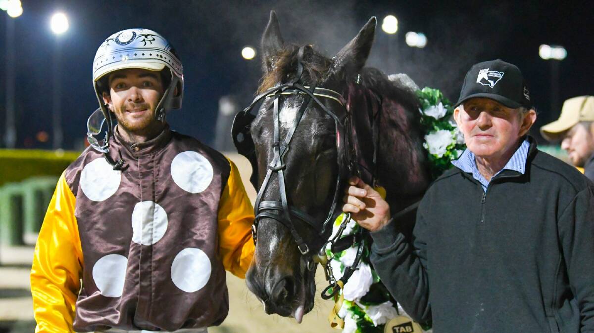 SPOILS OF SUCCESS: Peter McRae and Trevor White celebrate Defiant's win in the Regional Championships State Final at Menangle on Saturday night. Picture: Racing at Club Menangle Trackside
