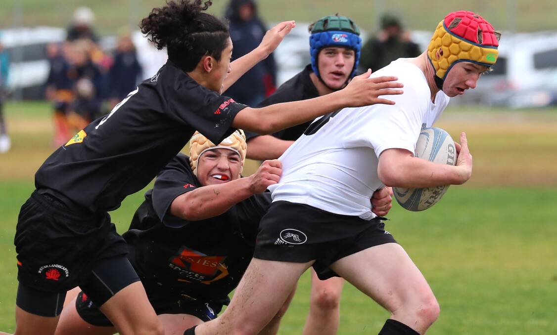 CAUGHT: Southern Barbarians player Tom Salmon tries to break out of a Griffith tackle attempt by Jishain Harrison at the rugby gala day in Wagga on Sunday. Picture: Les Smith