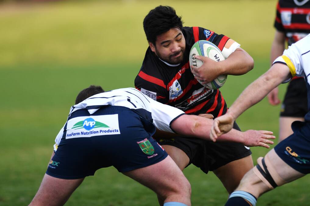 CHARGING AHEAD: Menzies Seumanutafa tries to fend off the Waratahs defence in Tumut's loss at Conolly Rugby Complex on Saturday.