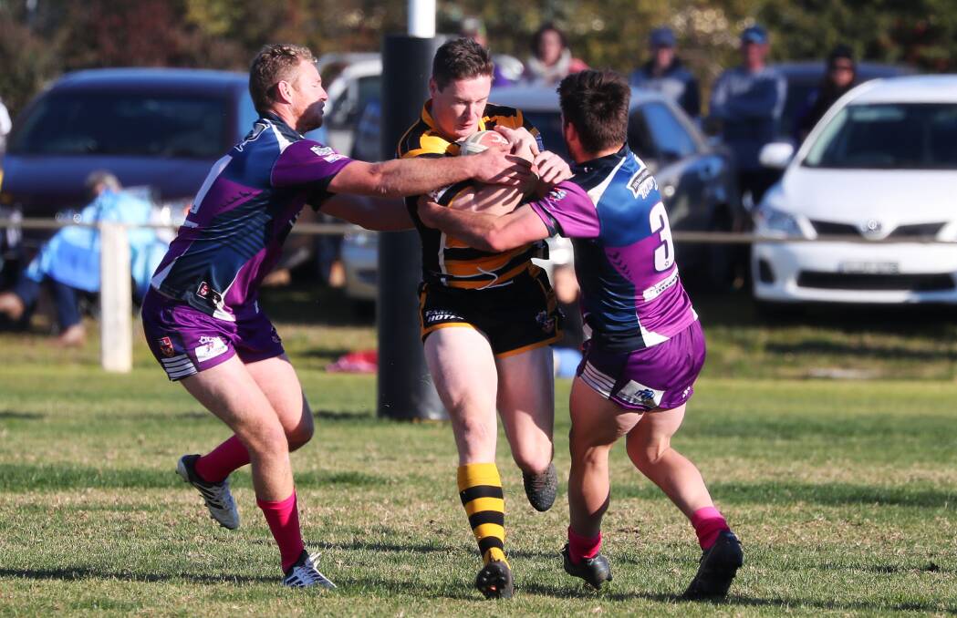 Dane O'Hehir getting tackled by Tim Hurst and Mitch Bennett during his last season with Gundagai in 2018.