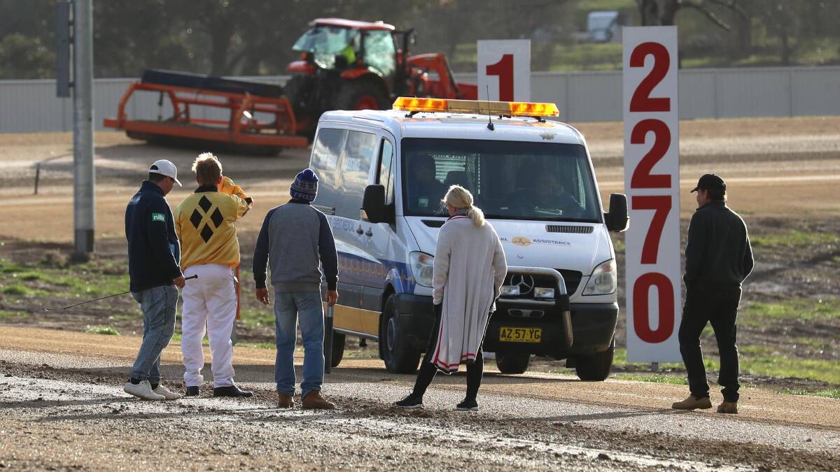 RACING NO MORE: Participants assess damage to the Riverina Paceway surface on Friday which saw the last two races abandoned. Picture: Les Smith