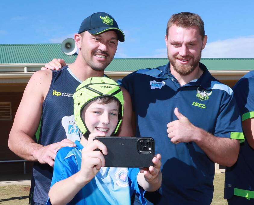 HAPPY SNAP: Sacred Heart student Jack Nightingale, 11, takes a selfie with Canberra Raiders players Jordan Rapana and Elliott Whitehead at the Mortimer Shield on Thursday. Picture: Les Smith
