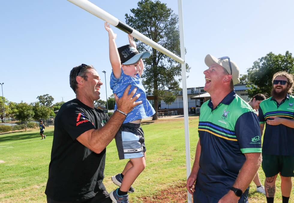 Brad Fittler helps Paddy Besgrove, 3, with his dad Tom, get a feel for the new rugby league goal posts at Jim Thompson Sporting Fields as the Coolamon Raiders look to take part in their first season of Group Nine junior rugby league. Picture by Les Smith