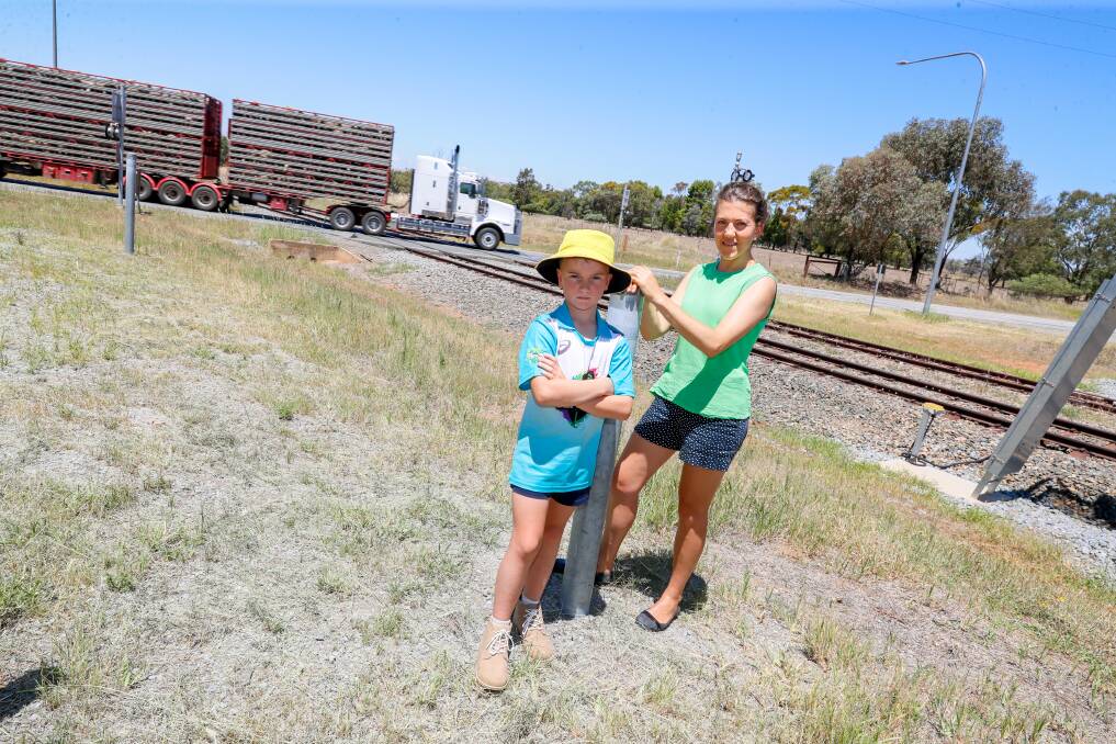 Old Junee residents Anna Lashbrook and son Henry Lashbrook, 8, are eager to see upgrades to the Goldfields Way level crossing. Picture by Les Smith