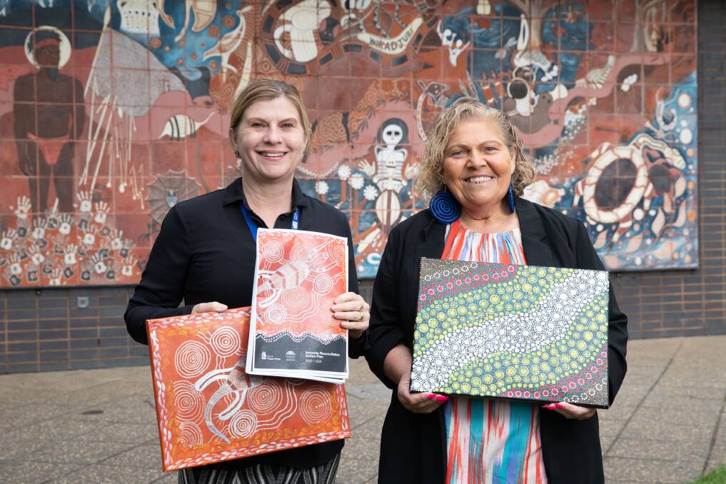 Wagga City Council community services director Janice Summerhayes and Wiradjuri elder Aunty Mary Atkinson holding the 2022-2024 RAP which shows Indigenous work by First Nations residents. Picture by Madeline Begley 