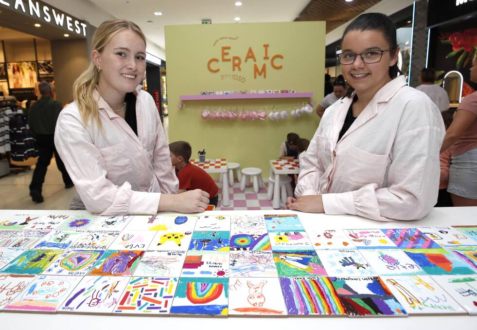 PRETTY IN PINK: Craft officers Ruby Browning (L) and Georgia Wastie with some of the decorated tiles. Picture: Les Smith 