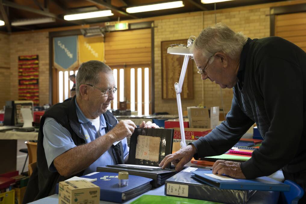 GOOD EYE: Wagga Stamp and Coin Club president Bob Edyvean examining a collection brought in by Alan Toe of Holbrook at the Stamp and Coin Fair. Picture: Madeline Begley 