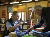 GOOD EYE: Wagga Stamp and Coin Club president Bob Edyvean examining a collection brought in by Alan Toe of Holbrook at the Stamp and Coin Fair. Picture: Madeline Begley 