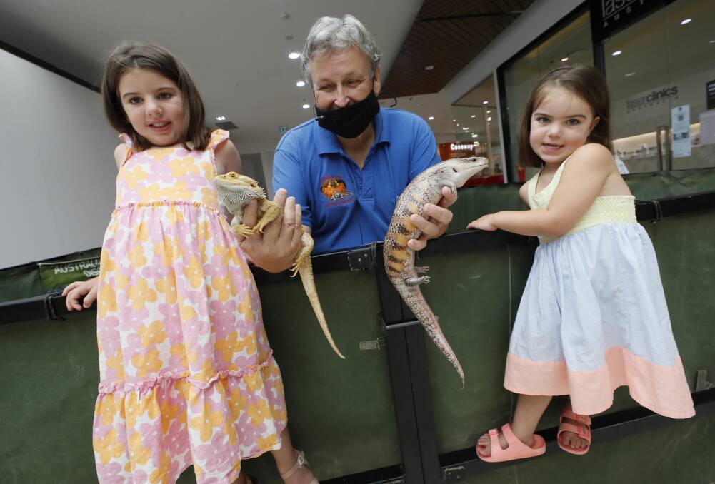 REPTILE TALKS: Bob Withey with the Broso sisters Audrey, 5 and Isla, 4, from Canberra and a bearded dragon and blue tongue lizard. Picture: Les Smith