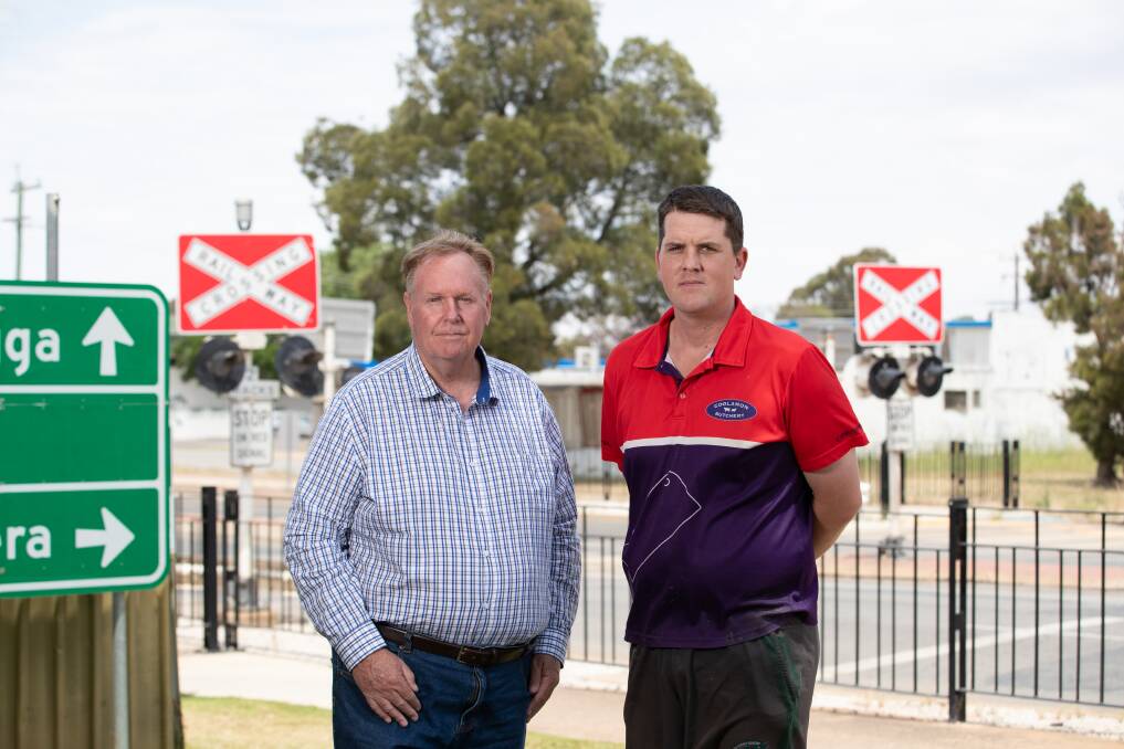 Coolamon mayor David McCann with Liam Armstrong at the town's railway crossing they say divides the town into two when trains come through. Picture by Madeline Begley 