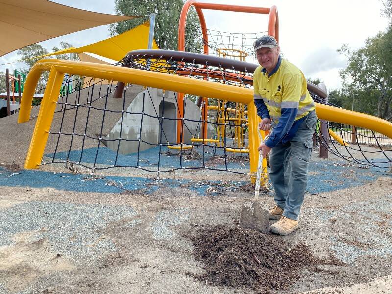 CLEANING UP: Wagga City Council works and playground officer John Conlan cleans the mud from the Riverside playground after recent floods. Picture: Wagga City Council 