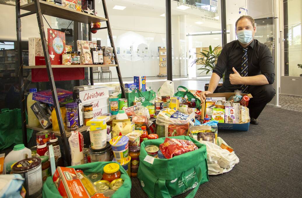 Wagga City Library acting manager Michael Scutti with some of the Christmas Food Appeal donations. Picture: Ash Smith
