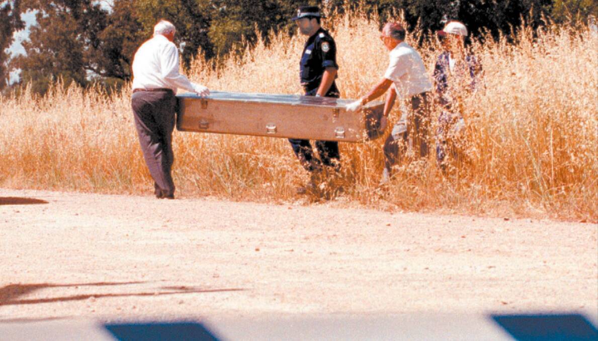 FLASHBACK: Police remove the body of missing Wagga man Ron Galvin from a table drain at Uranquinty on December 1, 1998. 