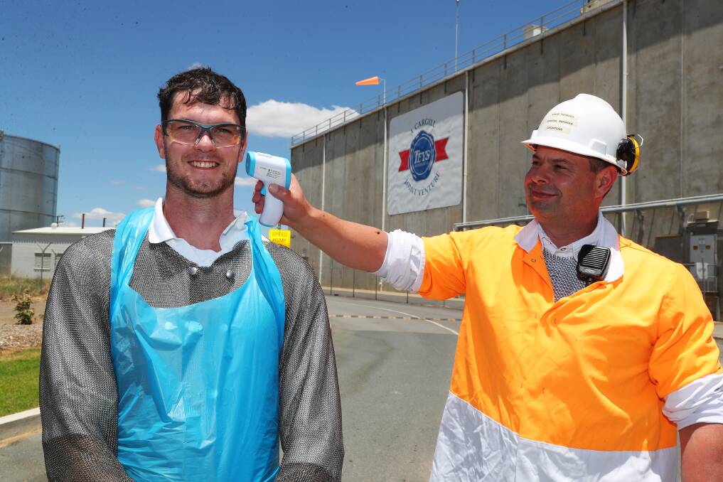 PRECAUTIONS: Dylan Williams and Stephen Thomson show that while there are no cases in Wagga, the Teys plant still conduct temperature checks. Picture: Emma Hillier 