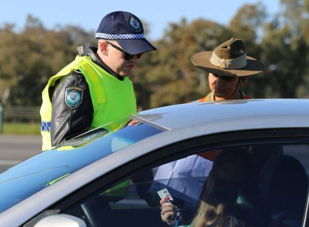 Soldiers and police check cars on their way through the border cross at Albury. Pictures: NSW Police